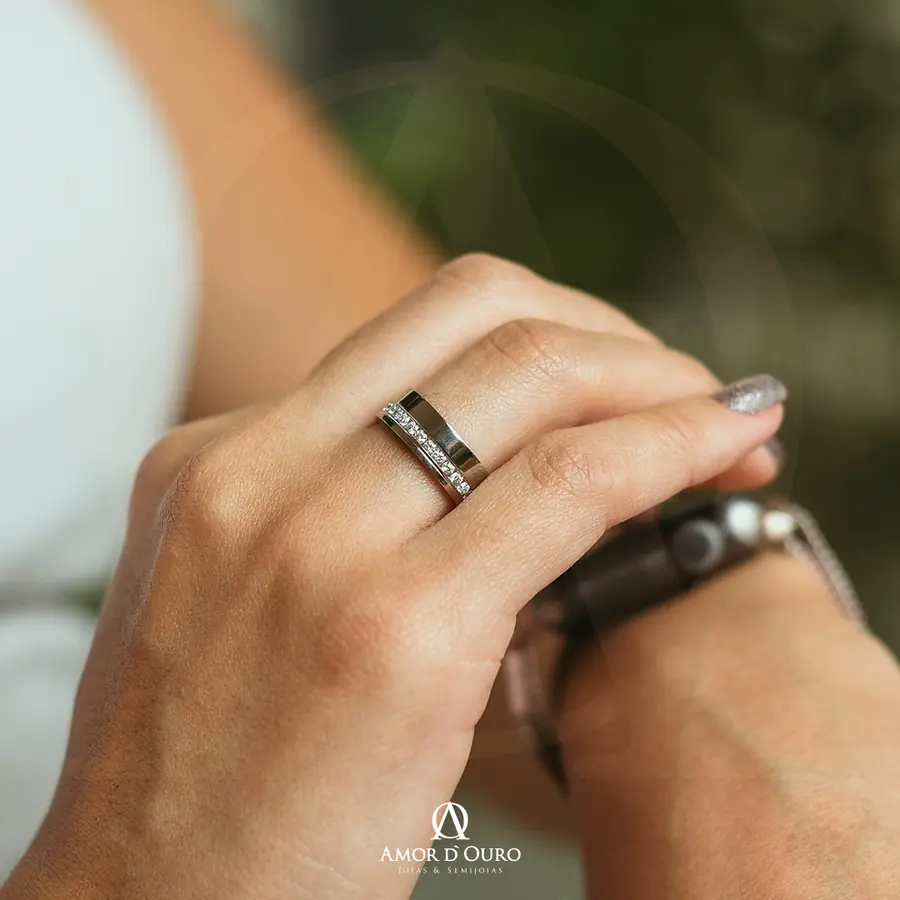Anel de compromisso prateado com fileira de diamantes em mão feminina